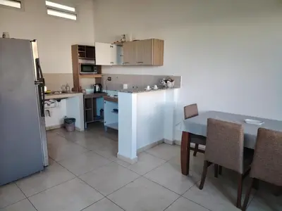a kitchen with a table and a table and chairs at Family house for 10 guest in Nejapa