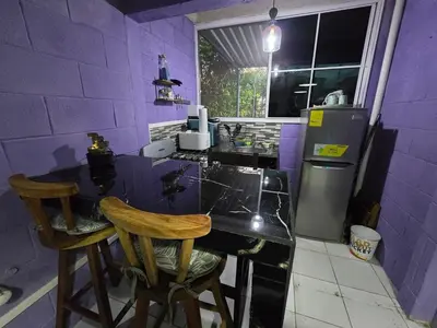 a purple kitchen with a counter and two chairs at Apartment with its own 100-inch cinema in Santa Ana