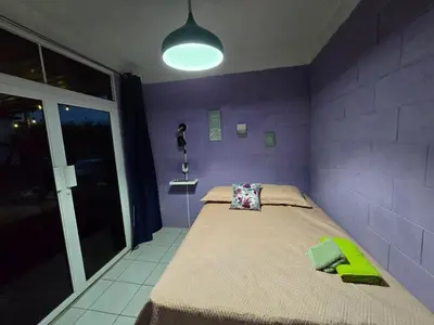 a purple bedroom with a bed with a purple wall at Apartment with its own 100-inch cinema in Santa Ana