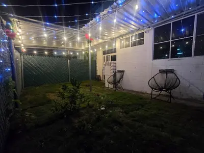a patio with lights on a house at night at Apartment with its own 100-inch cinema in Santa Ana