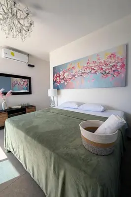 a bedroom with a large bed with a painting on the wall at Hotel y Restaurante Buganvilias