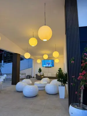 a living room with white chairs and lights at Hotel y Restaurante Buganvilias