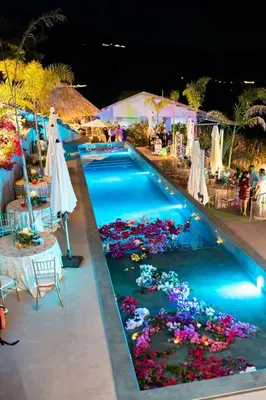 a swimming pool with flowers in the middle at Hotel y Restaurante Buganvilias