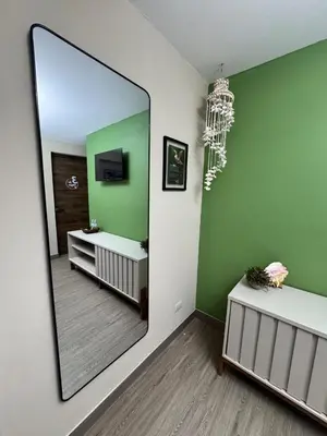 a bathroom with a large mirror and green walls at Casa Bri in Antiguo Cuscatlán