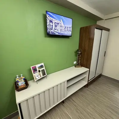 a room with a green wall with a counter and a refrigerator at Casa Bri in Antiguo Cuscatlán