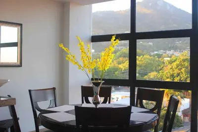 a dining room table with a vase with yellow flowers on it at Enjoy San Salvador in Torre 91 in San Salvador