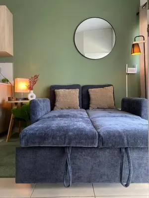 a blue couch in a living room with a mirror at Aluna House - Nuevo Sitio del Niño in San Juan Opico