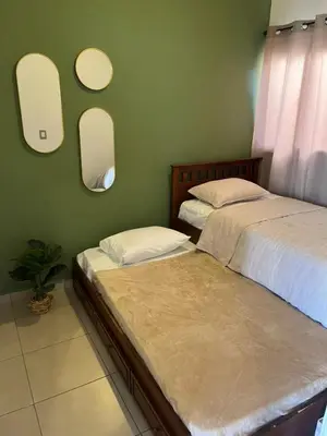 two beds in a bedroom with two mirrors on the wall at Aluna House - Nuevo Sitio del Niño in San Juan Opico