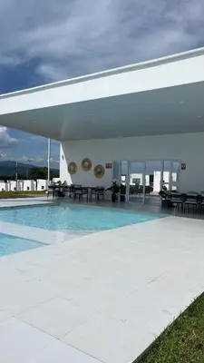 a building with a swimming pool with tables and chairs at Aluna House - Nuevo Sitio del Niño in San Juan Opico