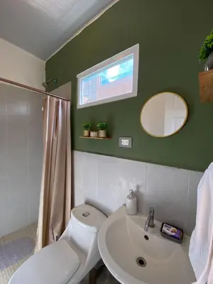 a bathroom with a white toilet and a sink at Aluna House - Nuevo Sitio del Niño in San Juan Opico