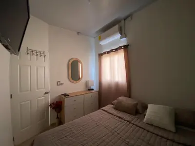 a bedroom with a bed and a dresser and a window at Aluna House - Nuevo Sitio del Niño in San Juan Opico