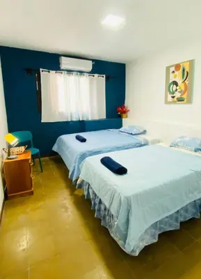 two beds in a room with blue walls at Hostal la casa de Ross in Santa Ana