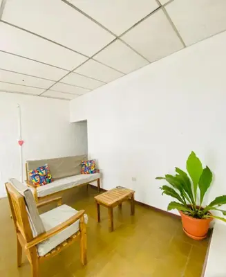 a room with a bench and a table and a plant at Hostal la casa de Ross in Santa Ana