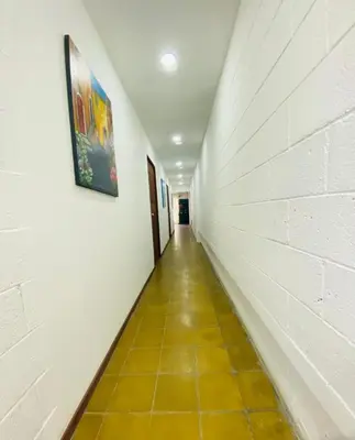a hallway with a tile floor and a painting on the wall at Hostal la casa de Ross in Santa Ana