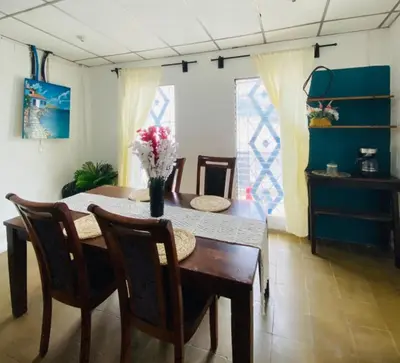a dining room table with a vase of flowers on it at Hostal la casa de Ross in Santa Ana