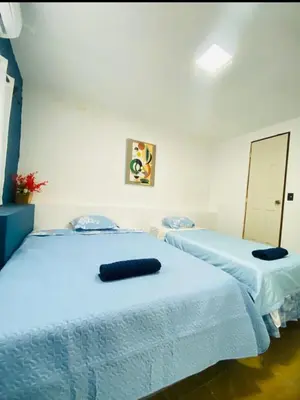 two beds sitting next to each other in a bedroom at Hostal la casa de Ross in Santa Ana