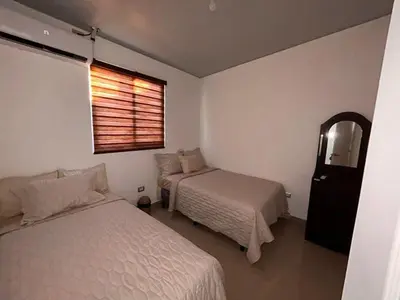 a bedroom with two beds and a window and a mirror at Nuevo San Miguel in San Miguel