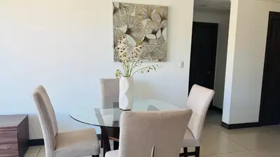 a dining room with a glass table and chairs at Torre Puerta el Alma-Luxury Stay-Frente Mall Multiplaza in Ceiba de Guadalupe