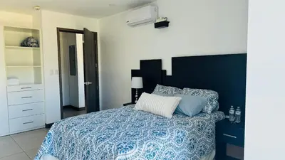 a bedroom with a bed with a blue comforter at Torre Puerta el Alma-Luxury Stay-Frente Mall Multiplaza in Ceiba de Guadalupe