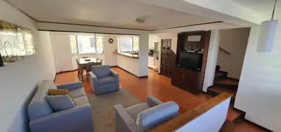 a living room with blue chairs and a television at Townhouse San Benito, La Mascota Terra in San Salvador