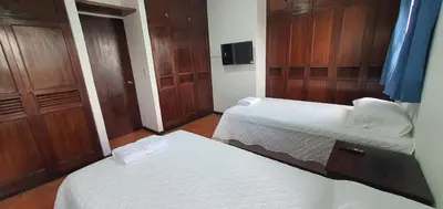 a small room with two beds and wooden cabinets at Townhouse San Benito, La Mascota Terra in San Salvador