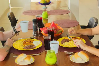 a group of people sitting around a table eating food at Casa Libre Guest House in Conchagua