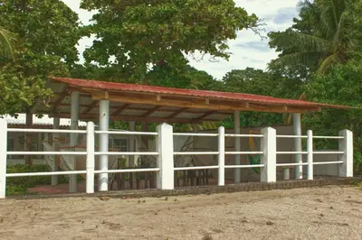 a pavilion with a white fence and trees at Casa Libre Guest House in Conchagua