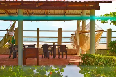 a patio with a table and chairs and the beach at Casa Libre Guest House in Conchagua