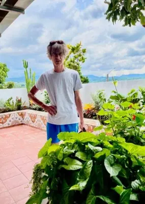 a woman standing on a patio near some plants at Casa Hogar in Ahuachapán