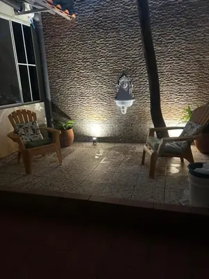 a patio with two chairs and a light in a building at Casa Hogar in Ahuachapán