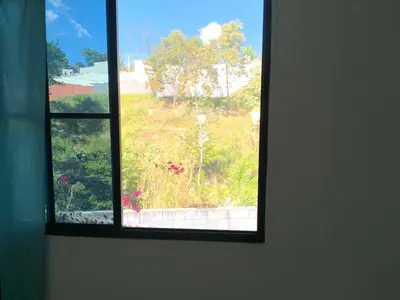 a window in a room with a view of a field at Hostal Casa compartida a 8 mins de San Salvador in San Salvador