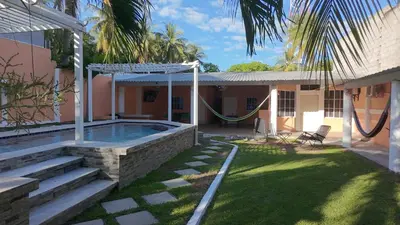 a house with a pool and a hammock in the yard at Villa Costabay in El Zapote