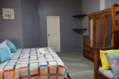 a bedroom with a bed and a wooden dresser at Villa Costabay in El Zapote
