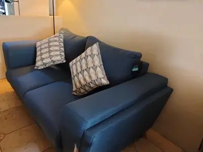 a blue couch with two pillows on it at Habitacion con aire acondicionado in San Salvador