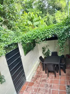 a patio with a bench and a table and chairs at Habitacion con aire acondicionado in San Salvador