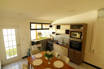 a kitchen with a wooden table and a dining room at Spacious Home - Cerca de Escalón in San Salvador