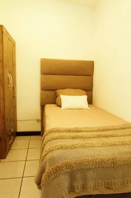 a bedroom with a bed with a pillow on it at Spacious Home - Cerca de Escalón in San Salvador