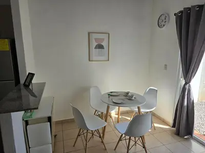 a dining room with a table and white chairs at San Francisco IV in San Miguel