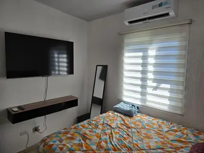 a bedroom with a bed and a tv and a window at San Francisco IV in San Miguel