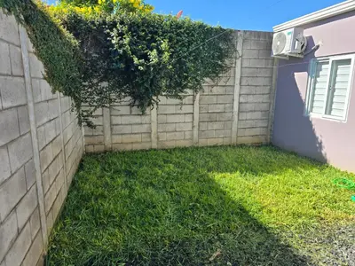 a fence with a hedge and grass at San Francisco IV in San Miguel