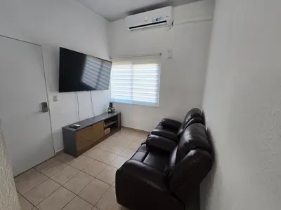 a living room with a leather couch and a flat screen tv at San Francisco IV in San Miguel