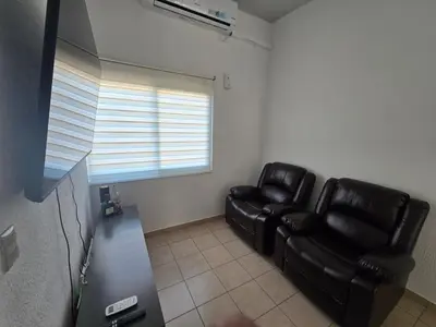 a living room with black leather chairs and a window at San Francisco IV in San Miguel