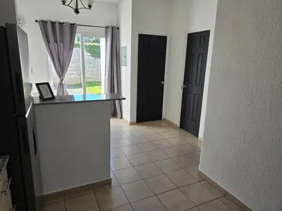a hallway with two black doors and a tile floor at San Francisco IV in San Miguel
