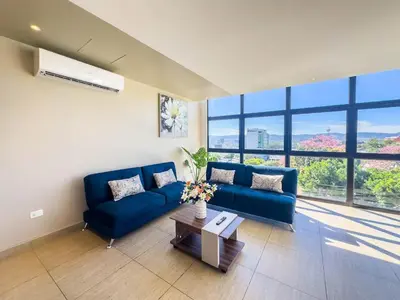 a living room with a blue couch and a table at Anthonini's Apartment 6 guests San Salvador in San Salvador