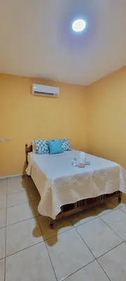a bedroom with a large bed with blue pillows at Kinta Mae Foster in San Pedro Masahuat