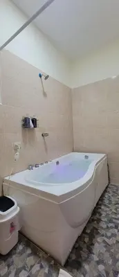 a large white tub in a bathroom with a toilet at Kinta Mae Foster in San Pedro Masahuat
