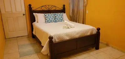 a bedroom with a bed with two towels on it at Kinta Mae Foster in San Pedro Masahuat