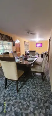a dining table and chairs in a living room at Kinta Mae Foster in San Pedro Masahuat