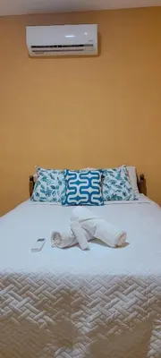 a bed with white socks and a air conditioner on it at Kinta Mae Foster in San Pedro Masahuat