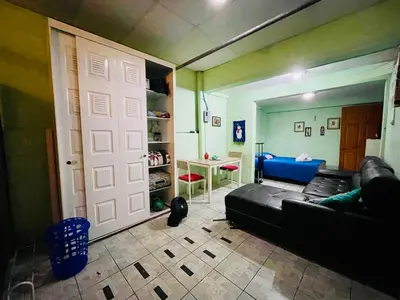 a living room with a black couch and a white door at Habitación privada en villa familiar en La Libertad in Zaragoza